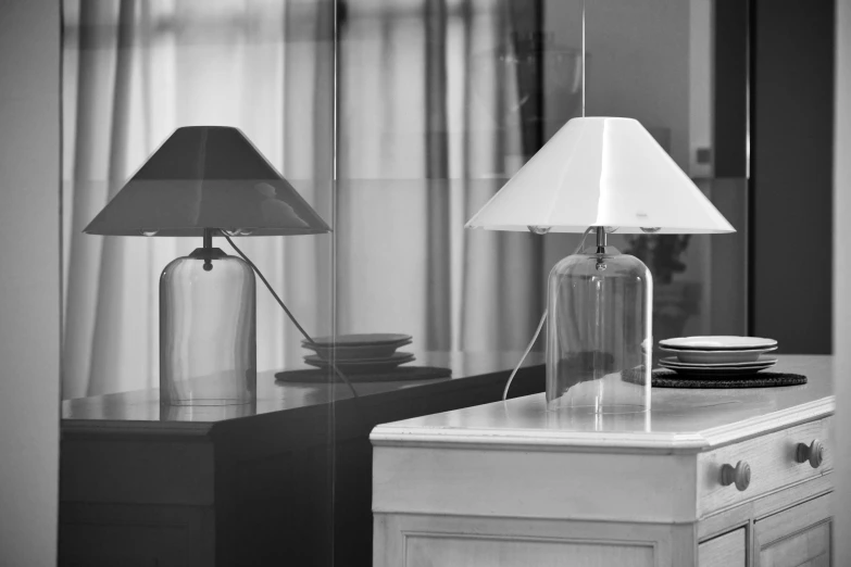 a tall glass lamp and some plates on a dresser