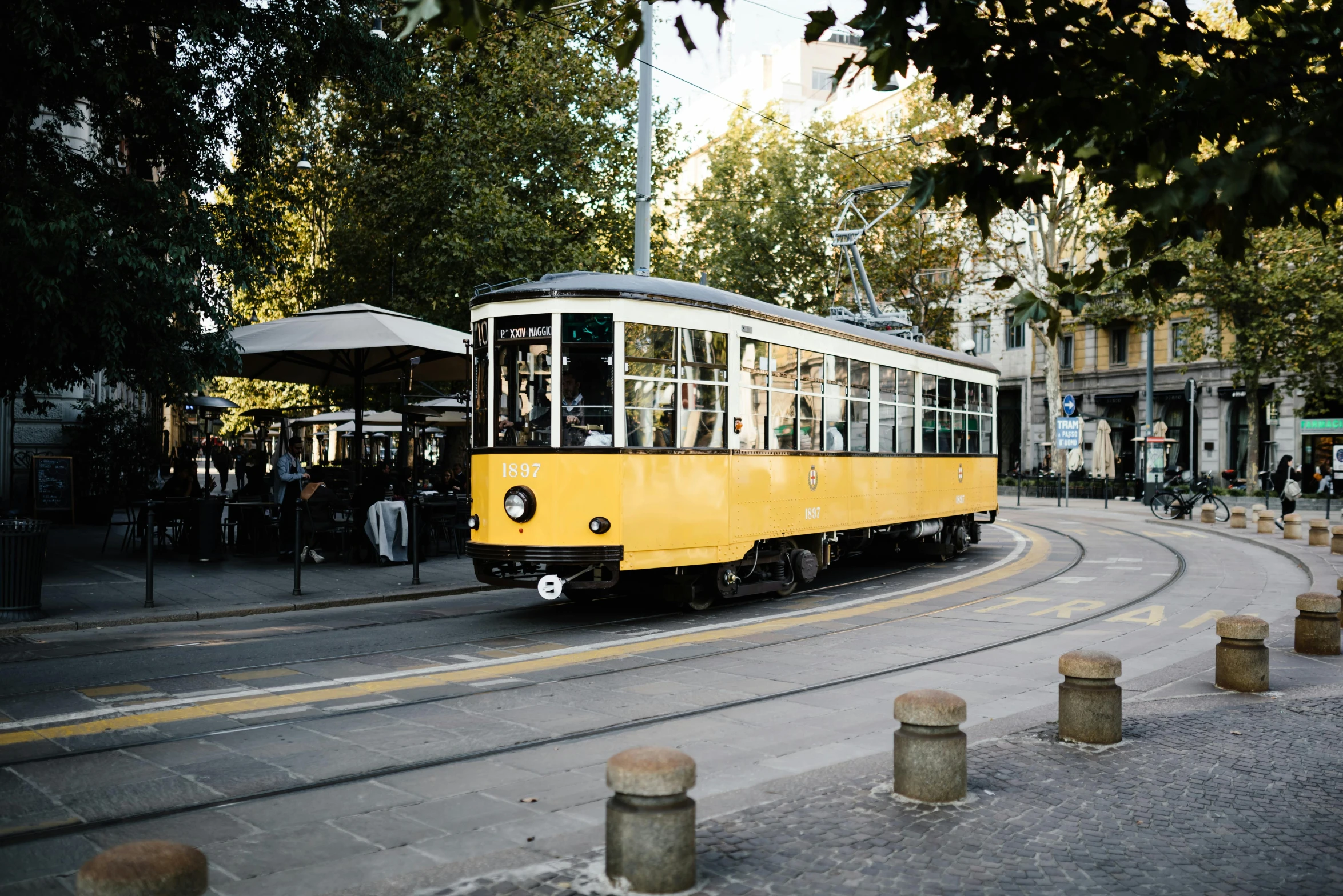 a yellow trolley traveling down a city street, by Matija Jama, pexels contest winner, viennese actionism, mies van der rohe, light tan, milan schere, grey