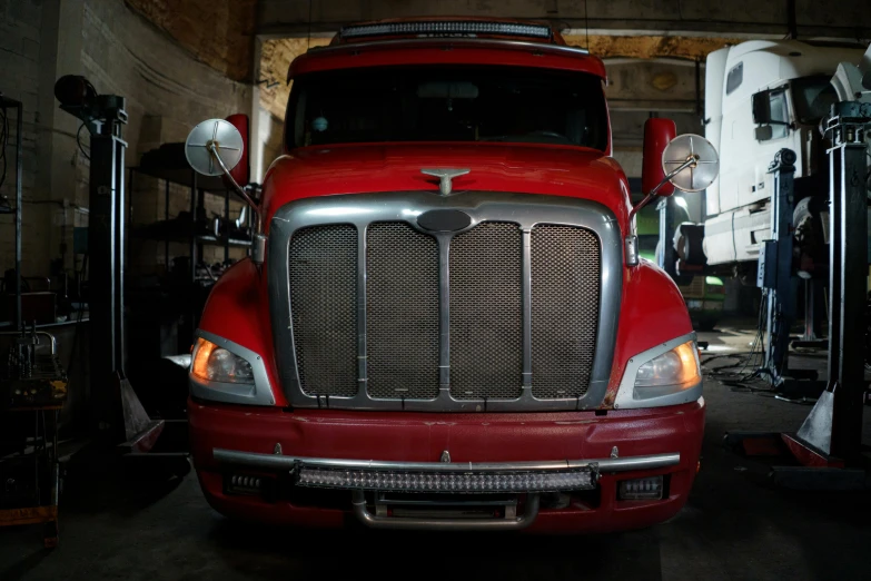 a red semi truck parked in a garage, a portrait, pexels contest winner, front, fan favorite, frontal view, 2 0 1 1