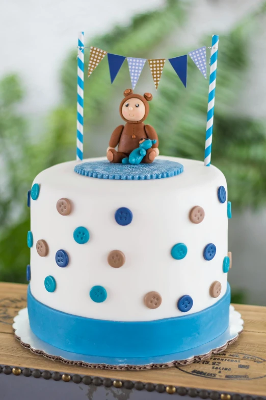 a cake sitting on top of a wooden table, inspired by George Barker, figuration libre, blue, monkey, polka dot, matte finish