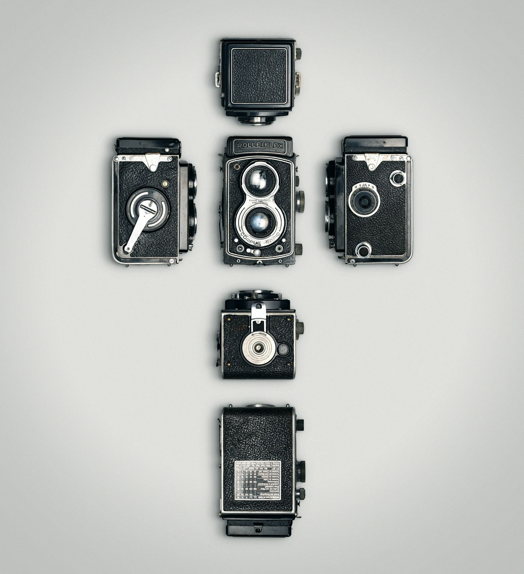 a group of old cameras sitting on top of each other, by Matthias Stom, bauhaus, cross, 8 x, hand, 5