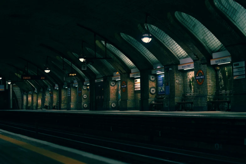 an empty train station at night with people waiting