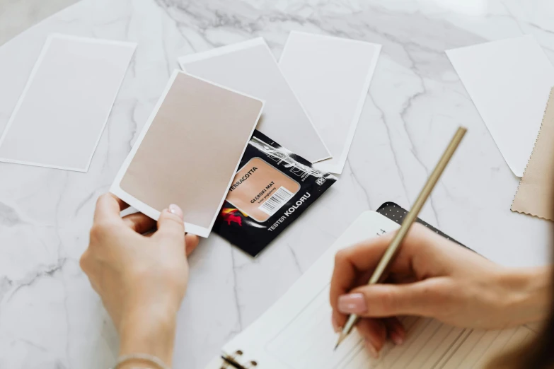 a woman sitting at a table writing on a piece of paper, a photorealistic painting, trending on pexels, card back template, pair of keycards on table, background image, polaroid picture