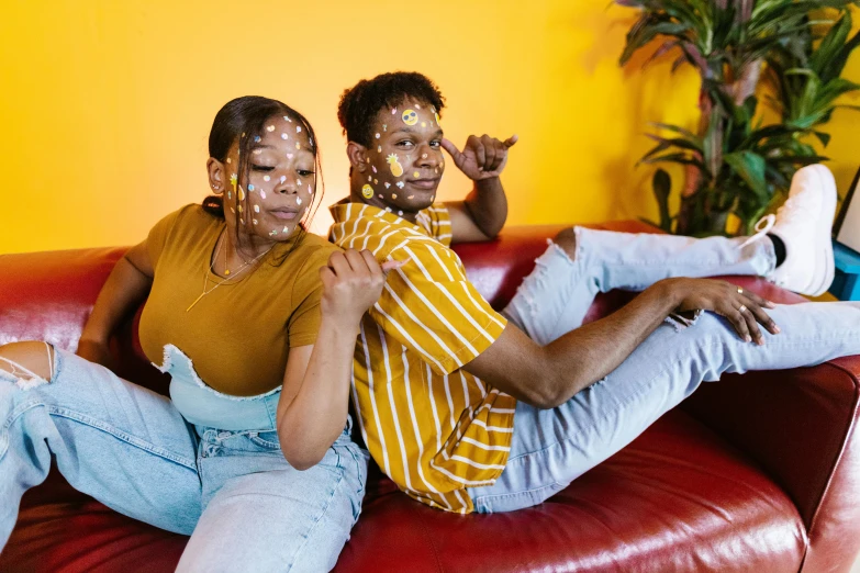 two people sit on a couch in front of a tv