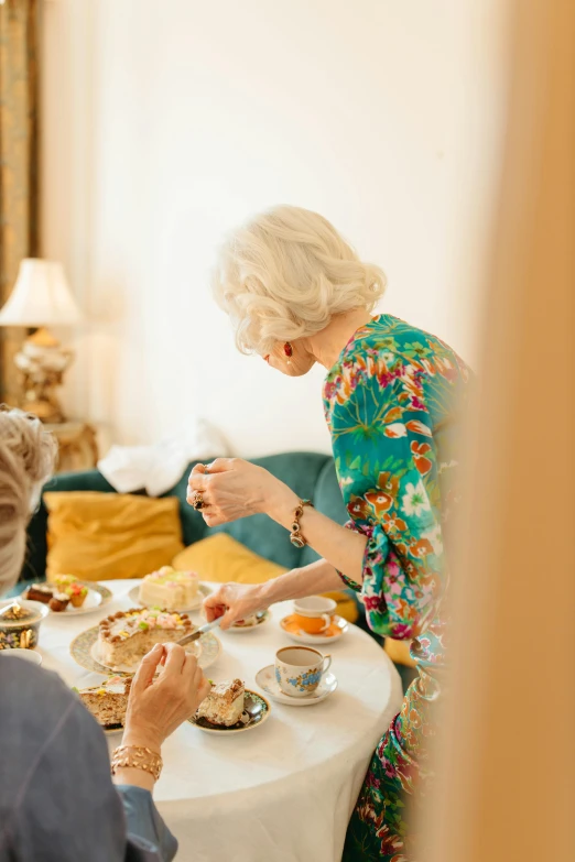 a group of people sitting around a table eating food, white haired lady, high-quality photo, tea party, profile image