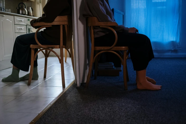 a couple of people that are sitting in a chair, inspired by Nan Goldin, pexels contest winner, faceless people, standing in corner of room, feet on the ground, people sitting at tables