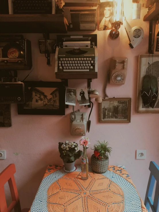 some typewriters are attached to the wall above a table