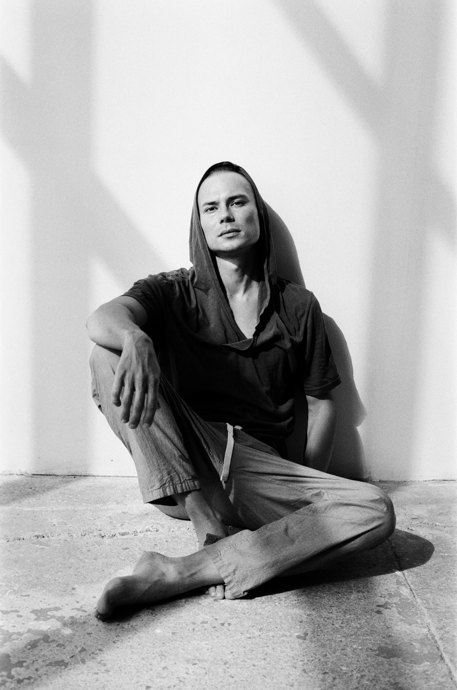 a black and white photo of a man sitting on the ground, frank dillane, 1999 photograph, rick owens, indigenous man