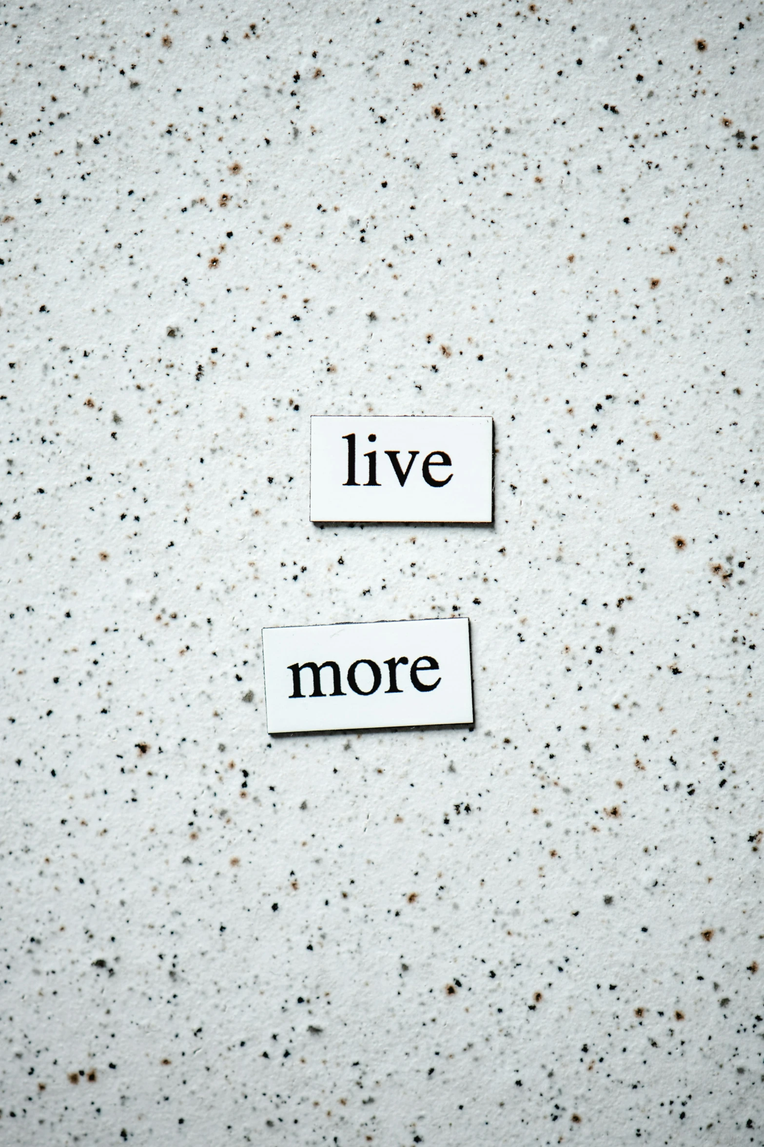 a piece of paper with the words live more written on it, unsplash, diptych, magnetic, made of concrete, thumbnail