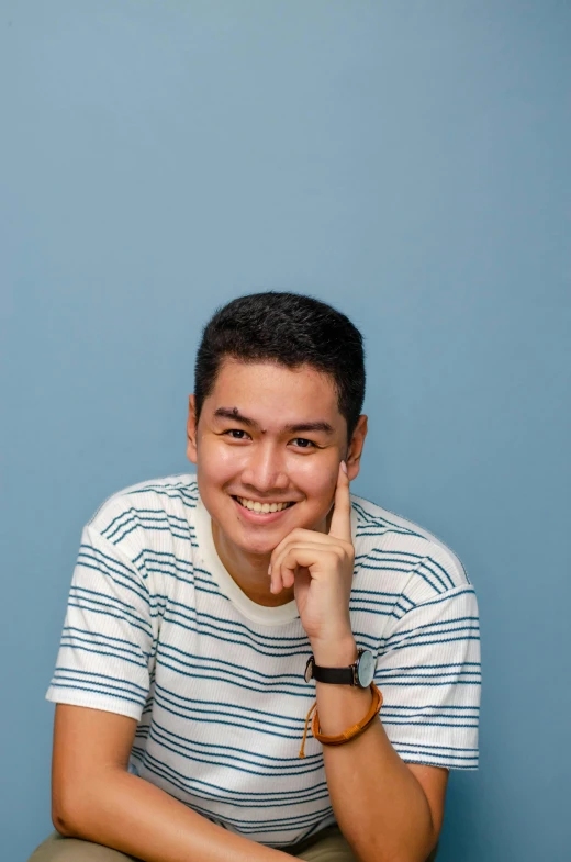 a man is smiling in front of a blue background