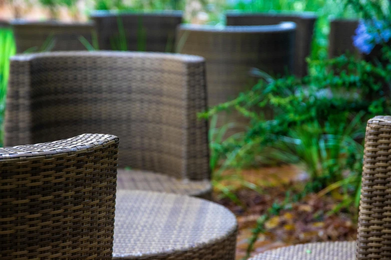 some gray wicker chairs some plants and grass