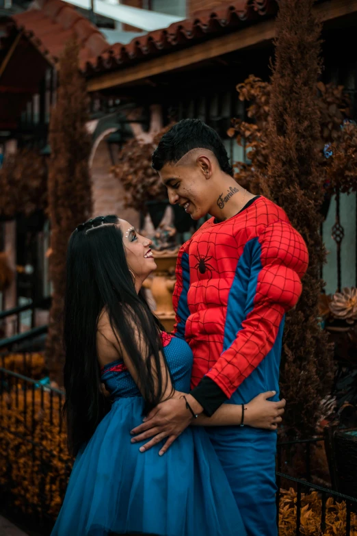 a woman in a blue dress standing next to a man in a spider - man costume, a cartoon, pexels contest winner, romantic couple, alanis guillen, profile image, 2717433015