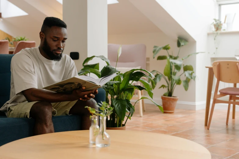 the man is reading the paper on his couch