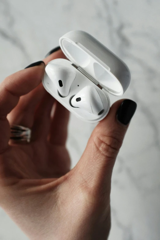 a person holding an airpods in their hand, by Christen Købke, trending on pexels, square, glossy white metal, homemade, f4”