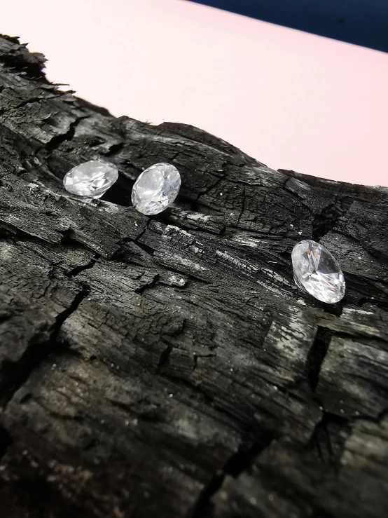 a bunch of diamonds sitting on top of a piece of wood, by Dóra Keresztes, sweat drops, giant earrings, concept photo, ((rocks))