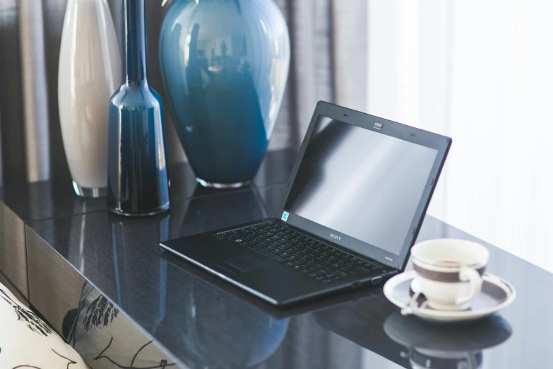 a laptop computer sitting on top of a black table, by Jay Hambidge, unsplash, decoration, inside a grand, noon, slate