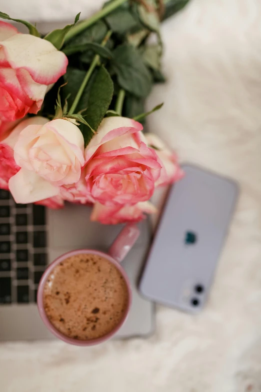 a laptop on the table near some flowers