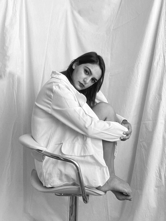 a black and white photo of a woman sitting on a chair, by Lucia Peka, phoebe tonkin, cinematic. by leng jun, artem chebokha, isabela moner