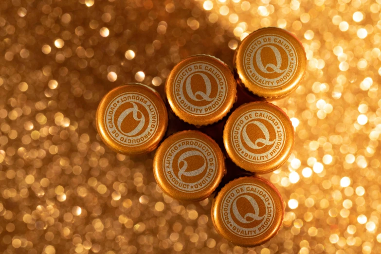 a bunch of chocolates sitting on top of each other, inspired by Enguerrand Quarton, beer logo, q, sparkling light, ochre