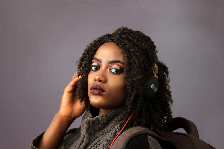 a woman with a backpack talking on a cell phone, an album cover, inspired by Chinwe Chukwuogo-Roy, trending on pexels, with professional makeup, looking to camera, wearing a gaming headset, close - up studio photo