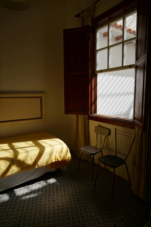 a small bed in front of a window with sunlight shining in