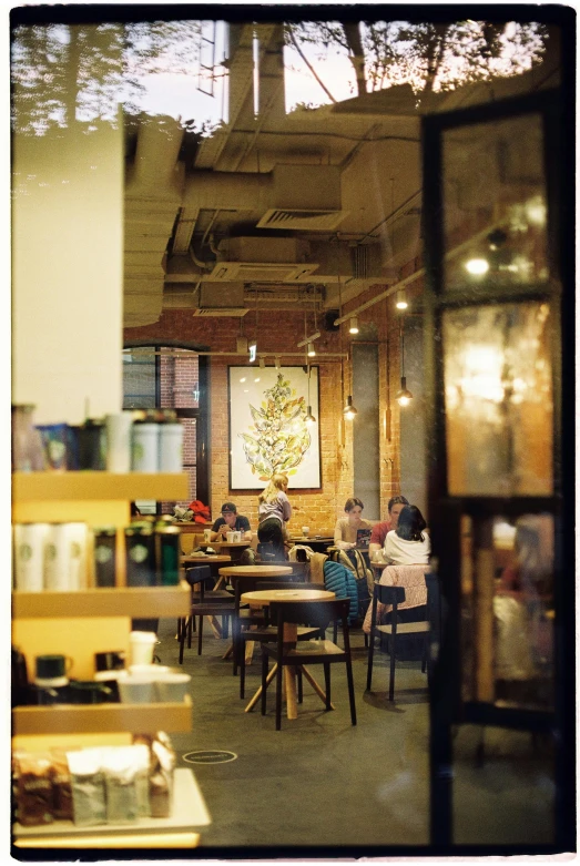 people sitting around tables in a room with a large picture