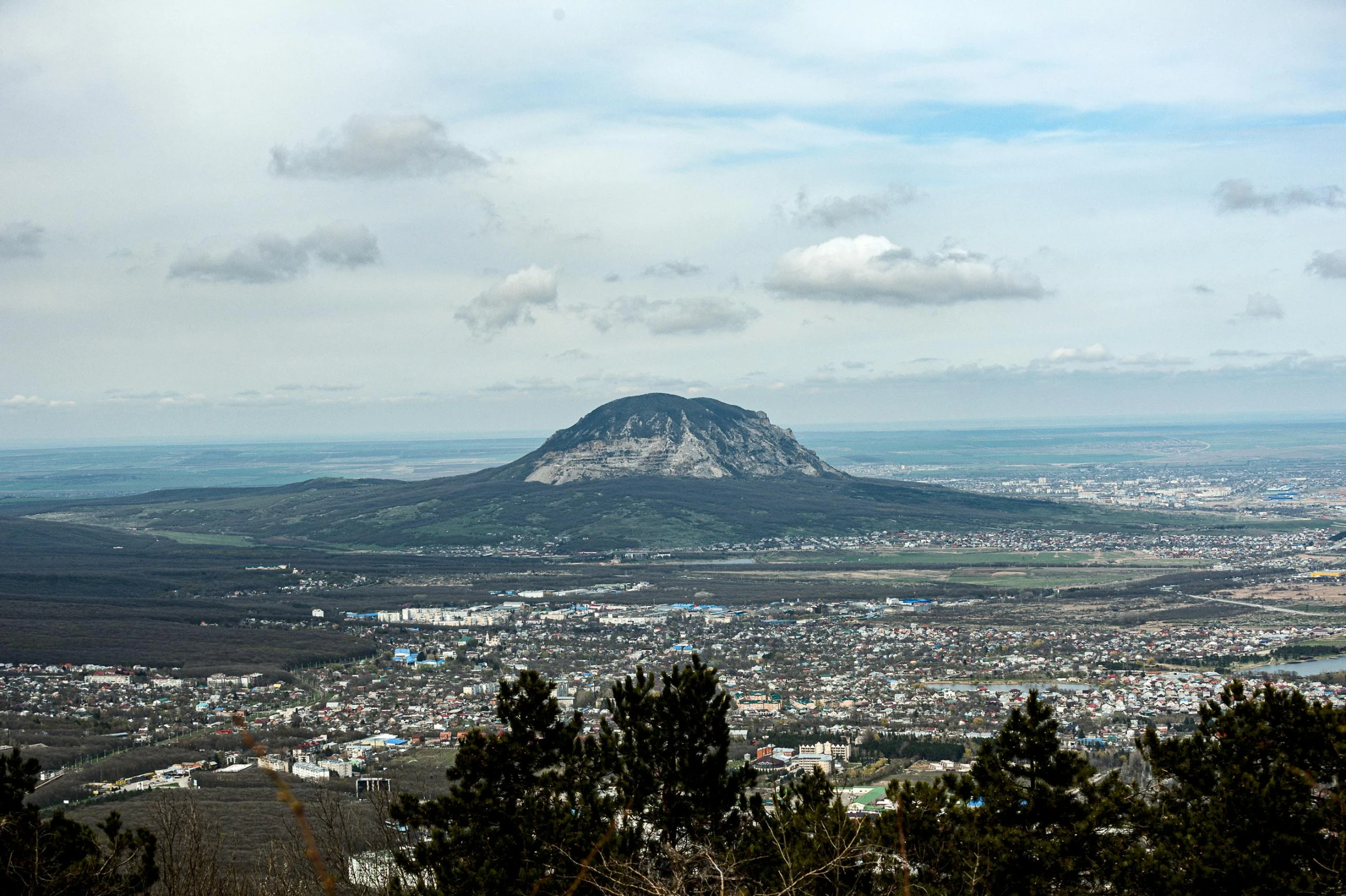 view over a city and mountain from the top of a hill