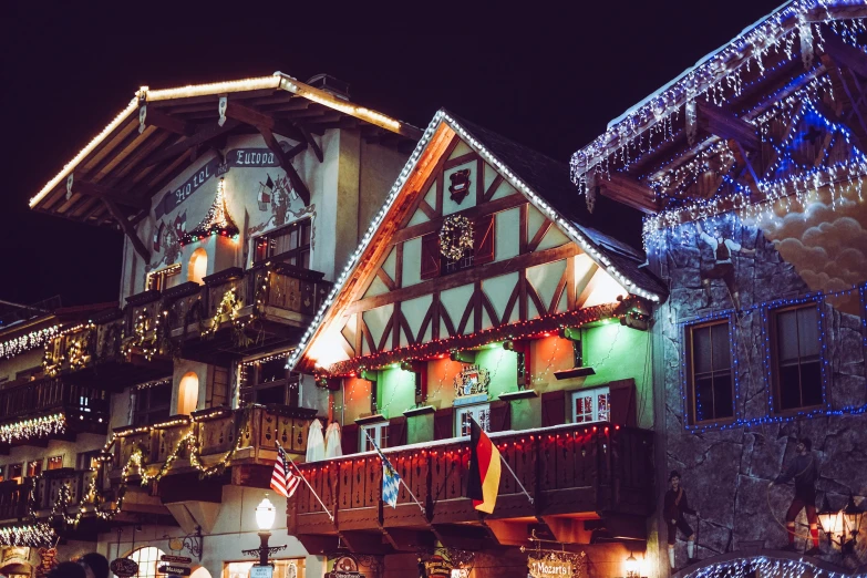 a group of buildings covered in christmas lights, pexels contest winner, renaissance, medieval tavern, gray, 💋 💄 👠 👗, alpine architecture