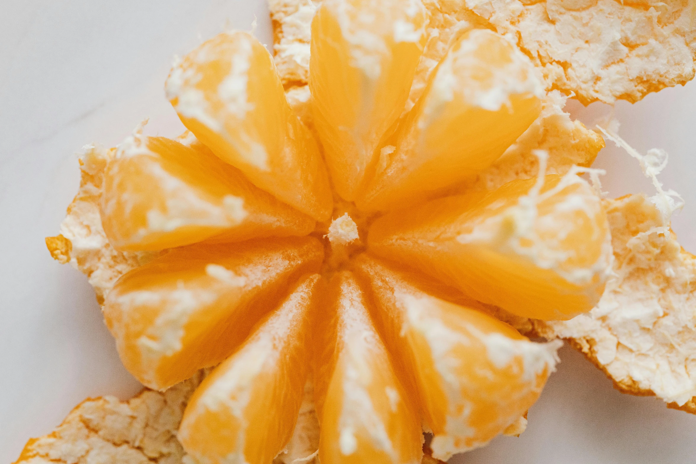 a peeled orange sitting on top of a white plate, by Carey Morris, pexels, eating cheese, starburst, close-up from above, cake