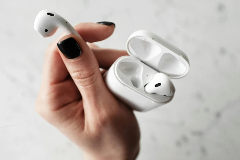 a person holding a pair of airpods in their hand, by Julia Pishtar, trending on pexels, square, “hyper realistic, white ceramic shapes, scientific