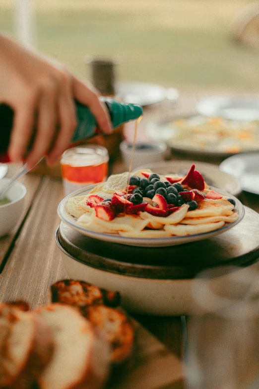 a person is spreading food onto a plate