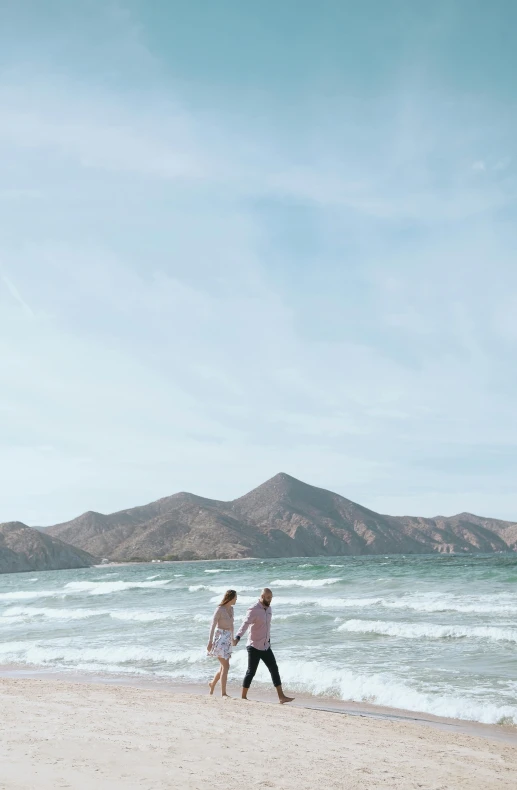 a couple walking on a beach next to the ocean, mountain, in the middle of the ocean!!!!!, trending on vsco, mexico