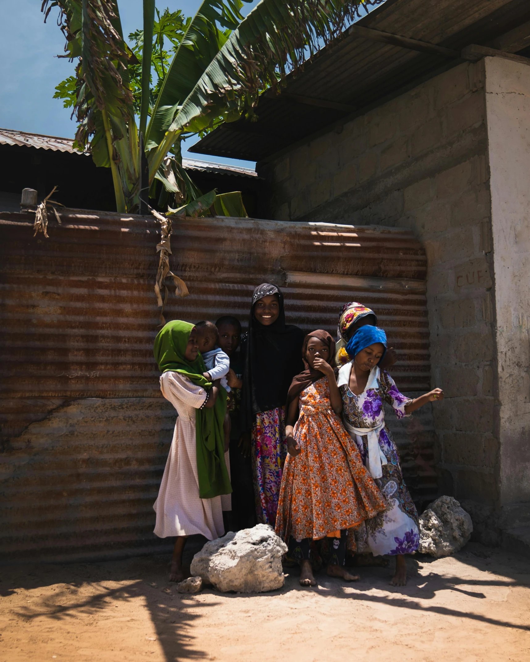 group of women in various clothing standing against a wall