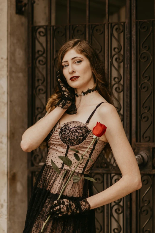 a woman wearing a black and beige couture holding a rose