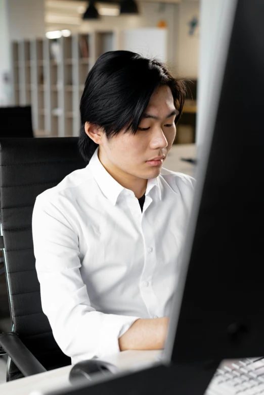 a woman sitting at a desk in front of a computer, inspired by Fei Danxu, reddit, wearing a white button up shirt, asian male, profile image, ignant