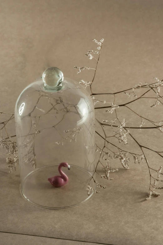 a glass clochet sitting on top of a table, inspired by Isidore Bonheur, figuration libre, flamingo, small in size, bells, minimalist