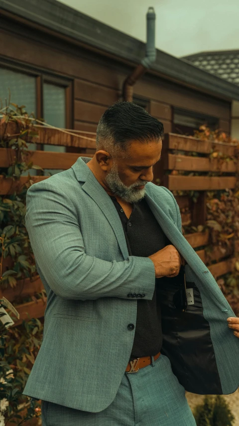 a man in suit and tie putting on his bag