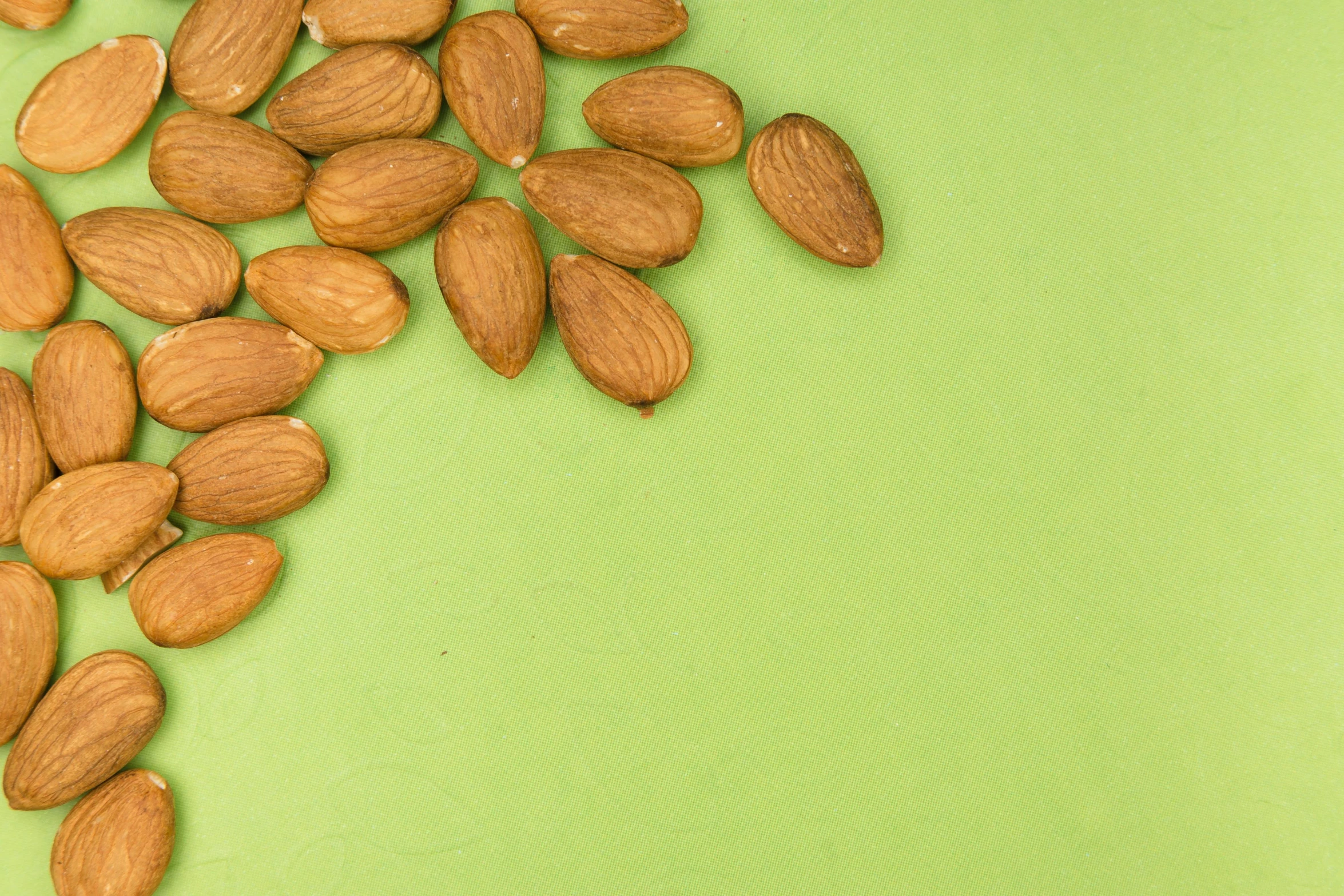 a pile of almonds on a green surface, trending on pexels, renaissance, background image, recipe, beige, leaked image