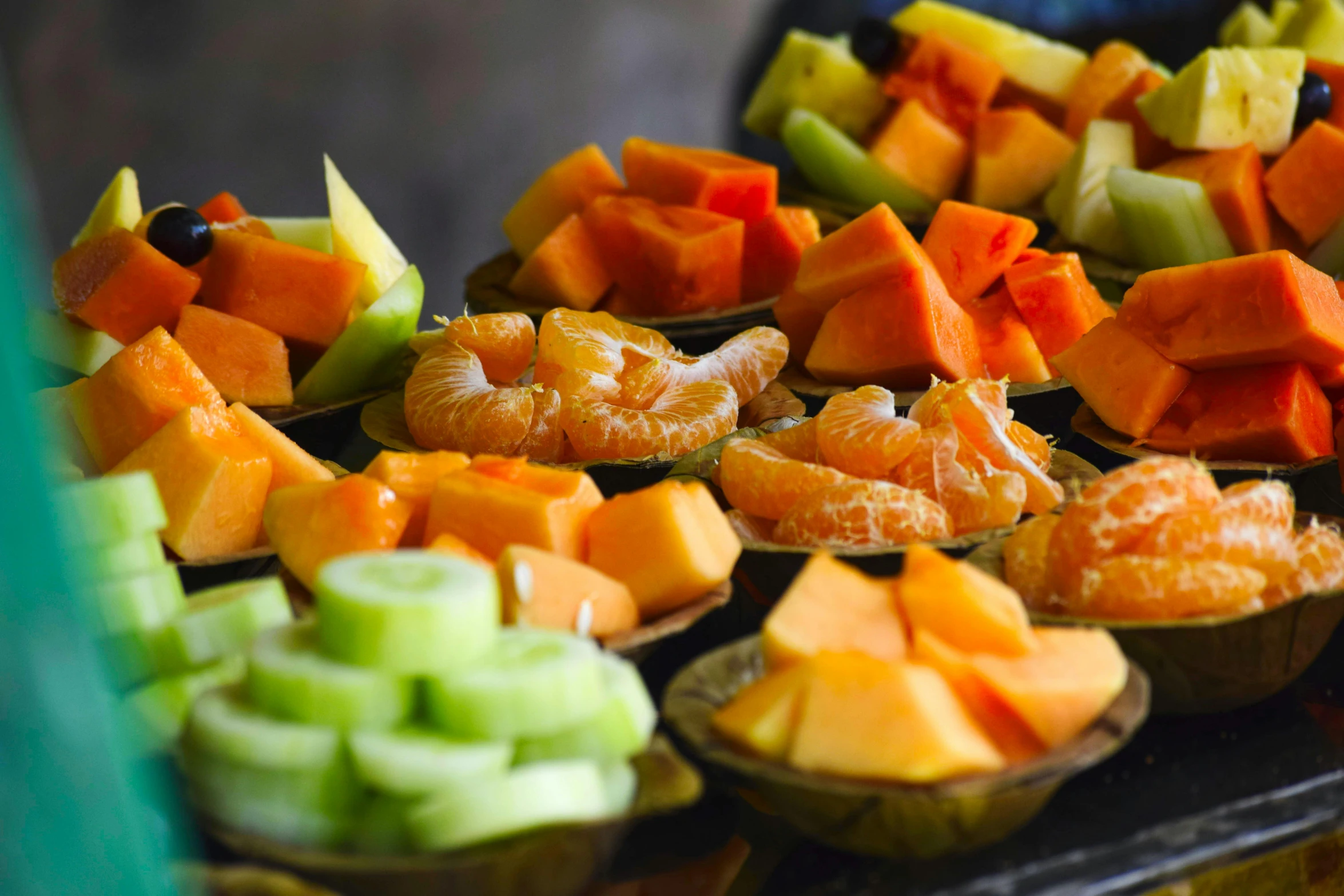 a tray of fruit sitting on top of a table, green and orange theme, hot food, cuts, up close