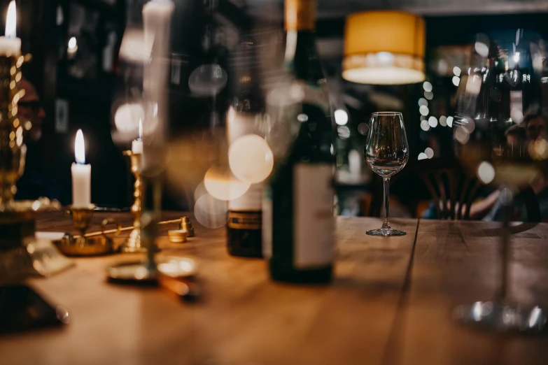 a wine glass sitting on top of a wooden table, pexels contest winner, busy night, long table, background image, casually dressed