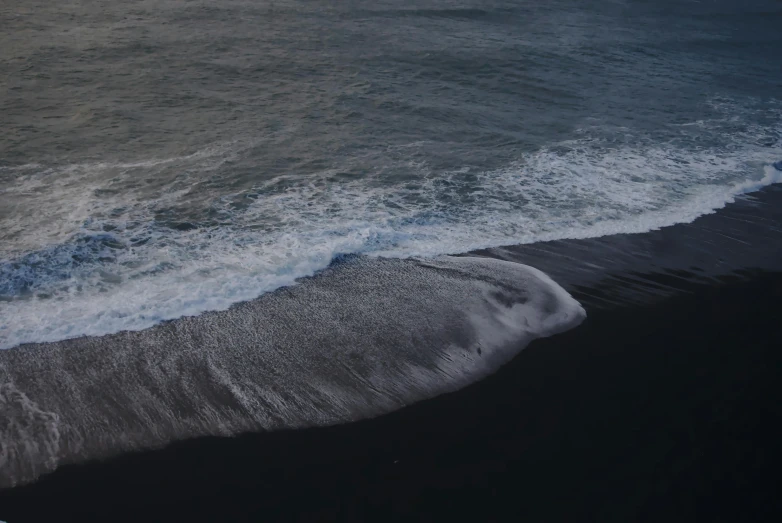 a man riding a surfboard on top of a sandy beach, pexels contest winner, surrealism, black sand, whale, seen from a plane, calmly conversing 8k