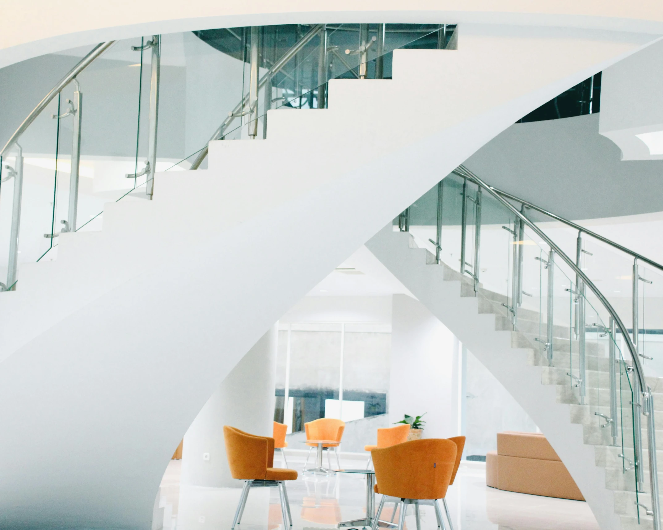 a living room filled with furniture and a spiral staircase, inspired by david rubín, pexels contest winner, white and orange, offices, steel archways, gleaming white