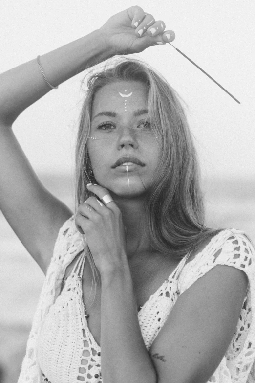 a black and white photo of a woman on the beach, tumblr, aestheticism, holding a magic needle, beautiful young ornella muti, wholesome techno - shaman lady, blonde swedish woman