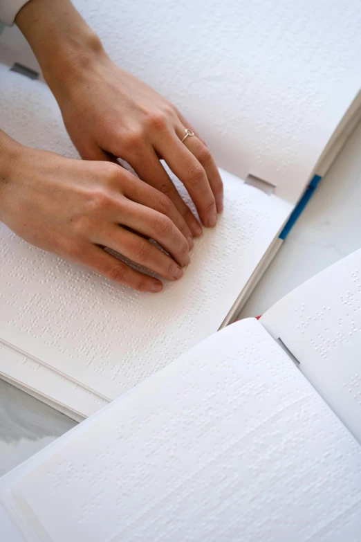 a close up of a person writing on a book, process art, soft white rubber, sleek hands, high textured, tangible