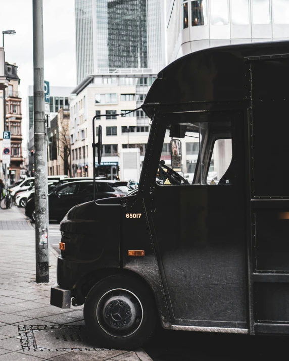 a black delivery truck parked on the side of a street, by Emma Andijewska, pexels contest winner, square, microbus, low quality photo, thumbnail