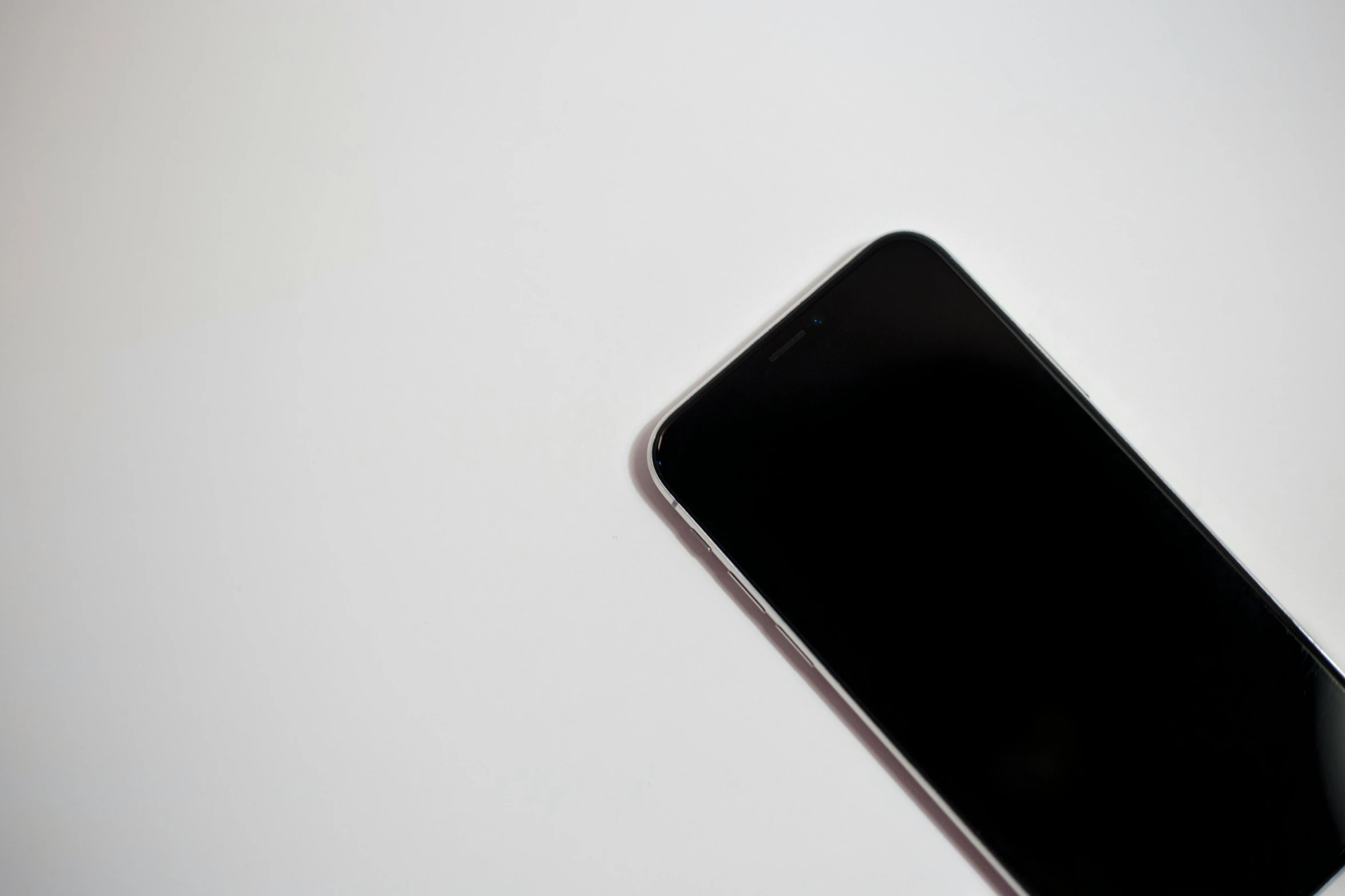 a close up of a cell phone on a table, by Robbie Trevino, minimalism, white background : 3, black main color, unblur, a long-shot