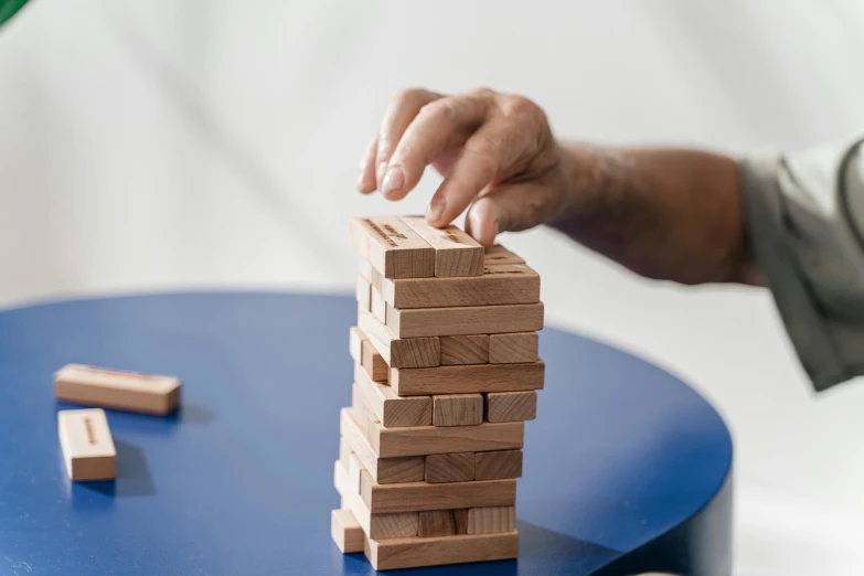 a person playing with wooden blocks on a table, by Emma Andijewska, unsplash, holding a tower shield, ultra realistic, casual game, upscaled to high resolution