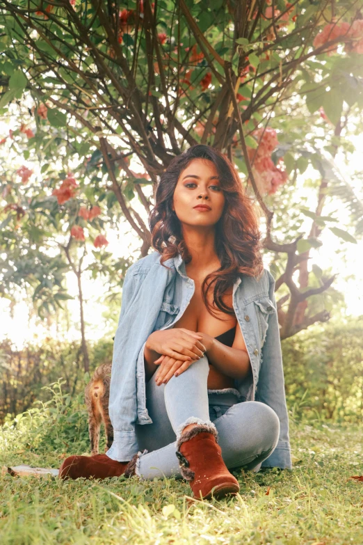 a woman is posing for a po under the tree