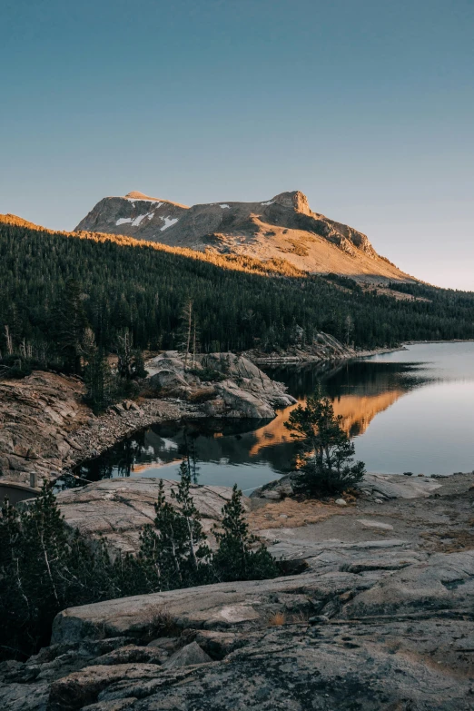 a calm lake in the woods surrounded by mountains