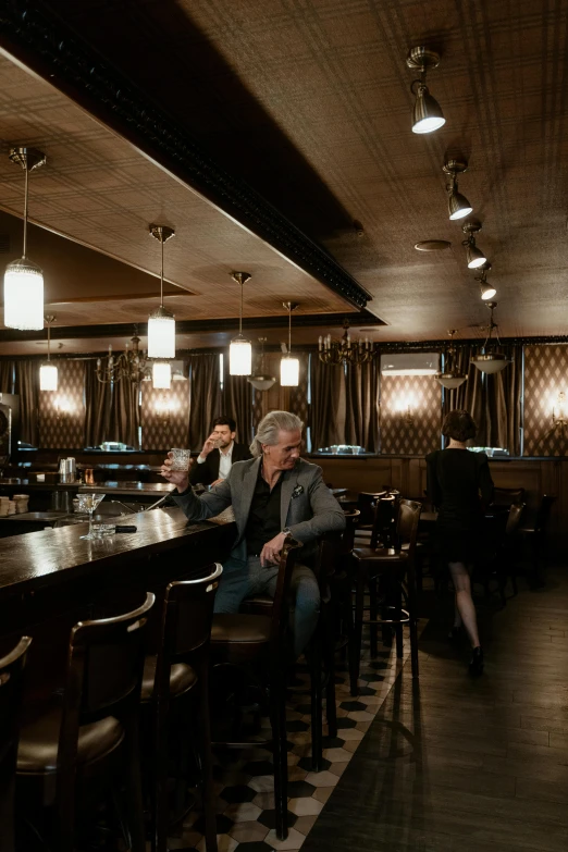 a man sitting at a bar with some drinks